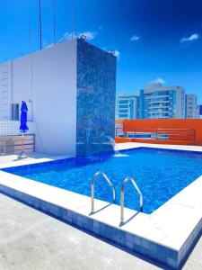 a swimming pool on the roof of a building at Studio na Jatiuca in Maceió