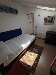 ein Schlafzimmer mit einem weißen Bett und einem Teppich in der Unterkunft AlpNest in Saint Vincent
