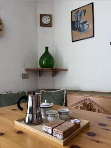 ein Tisch mit einem Teekessel und Tassen darauf in der Unterkunft AlpNest in Saint Vincent + 11 Fotos