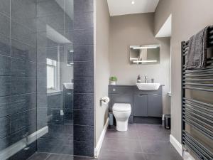 a bathroom with a shower and a toilet and a sink at Formans Lodge in Musselburgh +27 photos