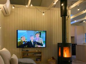 ein Fernseher an der Wand mit drei Männern darauf in der Unterkunft Holiday Home Between Beach And Forest On Mors in Sillerslev + 11 Fotos