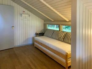 ein großes Bett in einem Zimmer mit Fenster in der Unterkunft Holiday Home Between Beach And Forest On Mors in Sillerslev