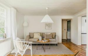 a living room with a couch and a table at Relaxing Villa With Fireplace And Private Stream in Lerdala