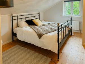 a bedroom with a black bed with white sheets and pillows at Relaxing Villa With Fireplace And Private Stream in Lerdala