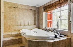 a large bathroom with a tub and a window at Relaxing Villa With Fireplace And Private Stream in Lerdala