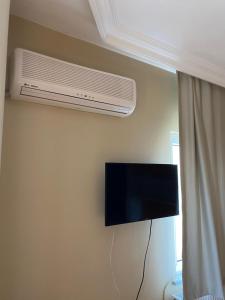 een televisie aan de muur met airconditioning bij Otel in Kumbağ