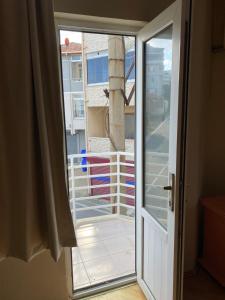 een glazen schuifdeur met uitzicht op een balkon bij Otel in Kumbağ