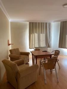 een woonkamer met een bank, een tafel en stoelen bij Otel in Kumbağ