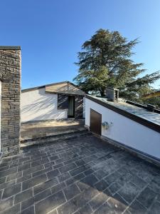 a house with a brick patio and a building at Castelvetri B&B in Castiglione dei Pepoli