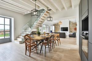 Saint-Hilaire-de-TalmontにあるVilla luxueuse rénovée à la Guittièreのテーブルと椅子のあるダイニングルームとリビングルーム
