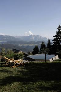 a pile of wood in front of a building with mountains at Historic Alpine Lodge In The Heart Of South Tyrol in Villandro