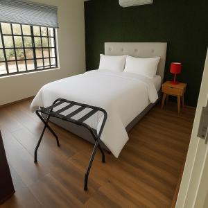 a bedroom with a large white bed with a red lamp at Hippo Zwartkop Suites in Centurion