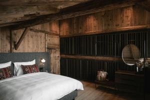 a bedroom with a large bed and wooden walls at Historic Alpine Lodge In The Heart Of South Tyrol in Villandro