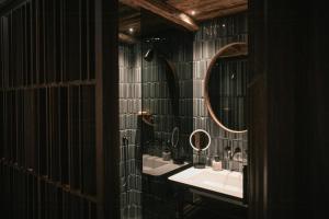 a bathroom with a sink and two mirrors at Historic Alpine Lodge In The Heart Of South Tyrol in Villandro