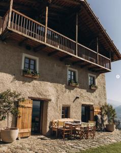 a table and chairs in front of a building at Historic Alpine Lodge In The Heart Of South Tyrol in Villandro