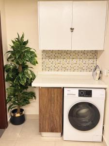 a kitchen with a washing machine under a counter at Modern 1 bedroom apartments in DHA in Lahore
