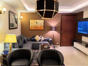 a living room with a couch and a tv at Modern 1 bedroom apartments in DHA in Lahore