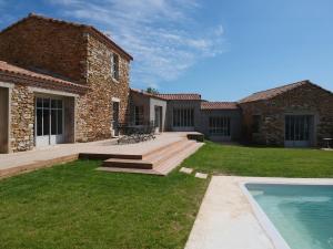 Saint-Hilaire-de-TalmontにあるVilla luxueuse rénovée à la Guittièreの家とスイミングプールのある裏庭