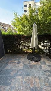 a white umbrella sitting on a stone patio at L'Écrin Secret Romantic Love Room & Private Spa in Ambilly