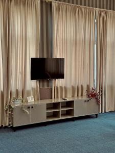 バクーにあるOlive Seaside Hotelのカーテンの前のキャビネットの上に置かれた薄型テレビ