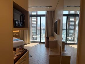 a hotel room with a bed and a television at Pavilion Hotel Al Jaddaf in Dubai