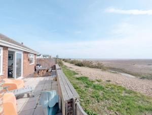 a house with a deck with a view of the beach at Sea Urchin and Shepherds Hut on the Beach in Pagham