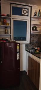a kitchen with a refrigerator and a tv on the wall at Gurgaon 21 Tonic & Twinkle in Gurgaon +7 photos