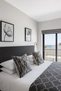 Un dormitorio con una cama grande con una ventana grande. en Mountain Bay Apartment with Sea and Mountain Views, en Simonʼs Town
