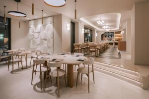 a restaurant with tables and chairs in a room at Cento Palme in Rhodes Town
