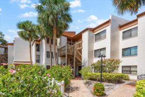 an apartment building with palm trees and plants at Book Me Baby! Bayview Beauty at Siesta Key in Siesta Key