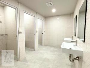 une salle de bains blanche avec un lavabo et un miroir dans l'établissement WJ Luxury Sathorn, à Bangkok