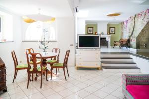 a living room with a table and a tv at Villa Danima in Capri +43 photos