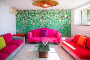 a living room with pink couches and a green wall at Villa Danima in Capri