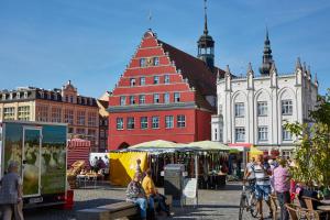 a group of people walking around a market with buildings at Design City Apartment Casper am Yachthafen in Greifswald