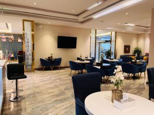 a restaurant with tables and chairs and a flat screen tv at Lian Park Hotel - فندق ليان بارك in Quai