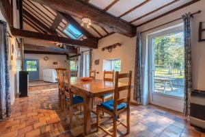 a kitchen and dining room with a wooden table and chairs at Charmante Bergerie in Castet