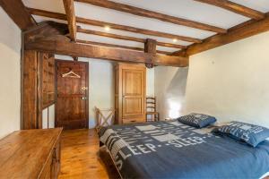 a bedroom with a bed in a room with wooden beams at Charmante Bergerie in Castet