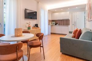 a living room with a couch and a table and chairs at Essenza INN Luxury Apartaments in Pescara