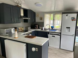 a kitchen with black cabinets and a white refrigerator at No 4 Dane Park in Lymington