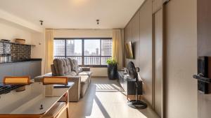 a living room with a couch and a window at Citizen Bueno by Marzani Host in Goiânia