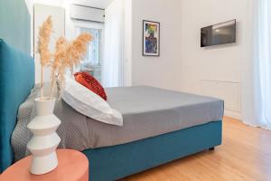 a bedroom with a bed with a vase on a table at Essenza INN Luxury Apartaments in Pescara