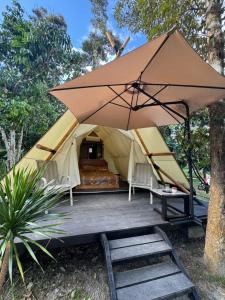 a tent with a bed and an umbrella at eagleye glamping langkawi in Pantai Kok +69 photos