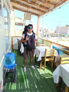Ein Mann mit Rucksack steht auf einem Balkon in der Unterkunft HOSPEDAJE WELCOME PARACAS peru in Paracas