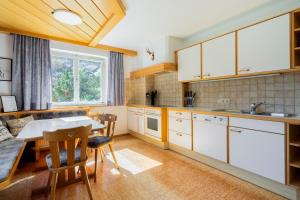 ヴァンダンスにあるhomy MontaVista - 300m zur Golmerbahnの白いキャビネットとテーブルと椅子のあるキッチン +28枚の写真