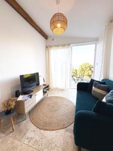 a living room with a blue couch and a large window at Tradition Corse et Modernité A Cantina in Granace