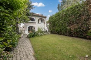 an exterior view of a house with a yard at Les Marguerites - Pavillon, Wifi, TV, 2 Parkings in Chevilly-Larue