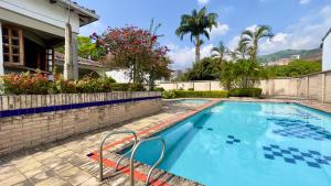a swimming pool in a yard with a house at Casa Veraneras de San Fernando in Cali