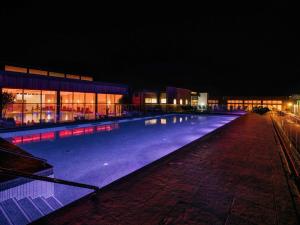 a large swimming pool in front of a building at night at Una Argentum 61 in Carbis Bay