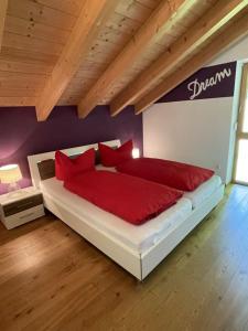 a bedroom with a large bed with red pillows at Ferienhaus Baumberger in Oberammergau