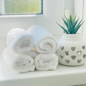a pile of towels on a shelf next to a vase at Bear Cottage - Waterfall Country in Glyn Neath +63 photos